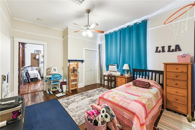 bedroom with dark hardwood / wood-style flooring, a closet, and ceiling fan