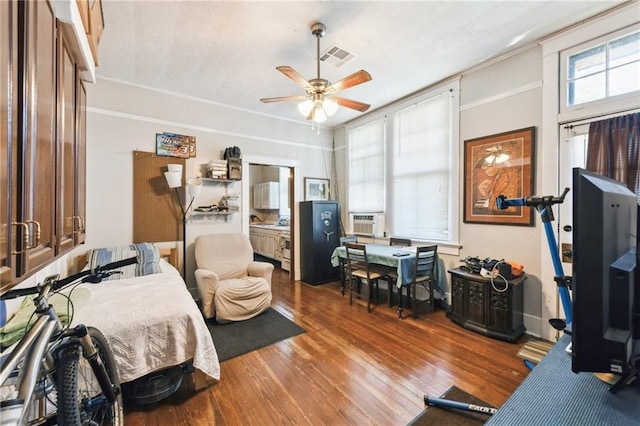 bedroom with cooling unit, ceiling fan, and hardwood / wood-style flooring