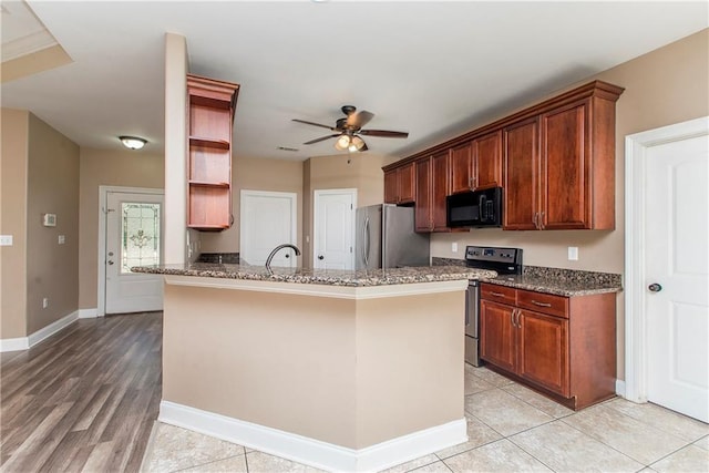 kitchen featuring ceiling fan, sink, kitchen peninsula, stone countertops, and appliances with stainless steel finishes