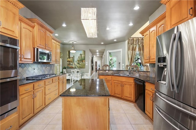 kitchen with sink, hanging light fixtures, stainless steel appliances, backsplash, and a kitchen island