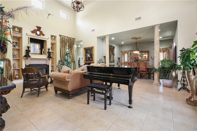 interior space featuring a chandelier, a towering ceiling, decorative columns, and light tile patterned flooring