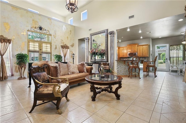 tiled living room with french doors, a wealth of natural light, and a high ceiling