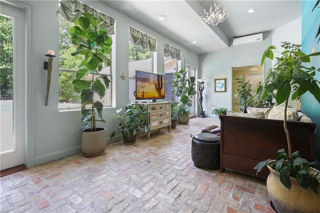 sunroom / solarium featuring a notable chandelier and an AC wall unit