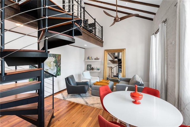 dining room featuring hardwood / wood-style floors, lofted ceiling with beams, and ceiling fan