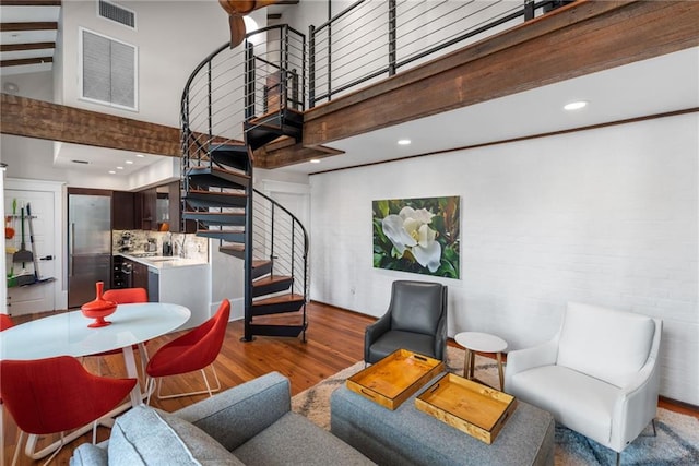 living room featuring high vaulted ceiling and light hardwood / wood-style floors