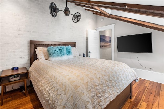 bedroom featuring lofted ceiling with beams and hardwood / wood-style floors