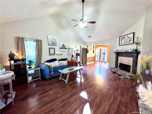 living room with dark hardwood / wood-style floors, ceiling fan, a fireplace, and high vaulted ceiling