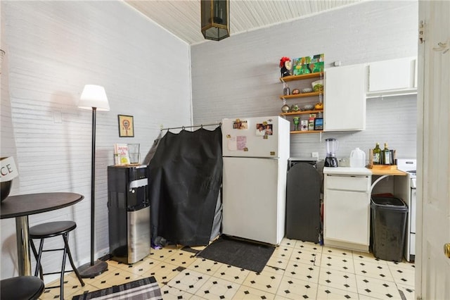 kitchen with white fridge and white cabinetry