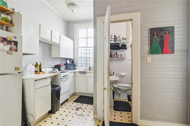 kitchen featuring white cabinetry, sink, and white appliances