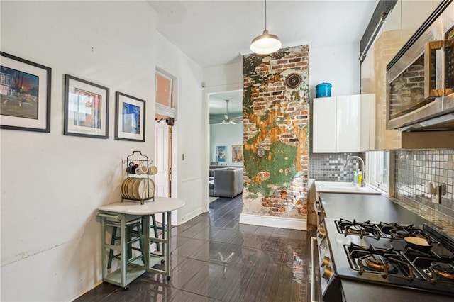 kitchen with white cabinets, sink, ceiling fan, tasteful backsplash, and stainless steel appliances