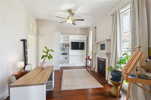 living room featuring a wealth of natural light, ceiling fan, and dark wood-type flooring