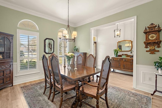 dining area with a chandelier, crown molding, and light hardwood / wood-style floors