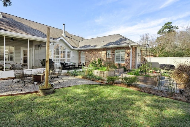 back of property with a lawn, a patio area, and ceiling fan