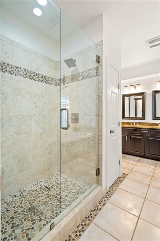 bathroom with tile patterned floors, vanity, and a shower with shower door