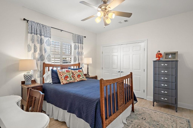 bedroom with ceiling fan, light hardwood / wood-style floors, and a closet