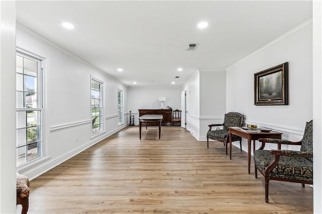 sitting room with light hardwood / wood-style flooring and ornamental molding