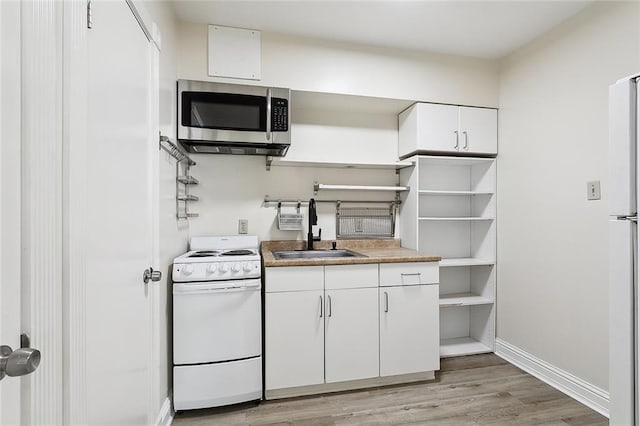 kitchen featuring white appliances, white cabinetry, light wood-type flooring, and sink