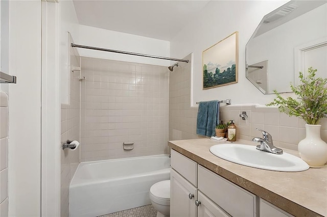 full bathroom featuring toilet, tile patterned flooring, backsplash, tiled shower / bath combo, and vanity