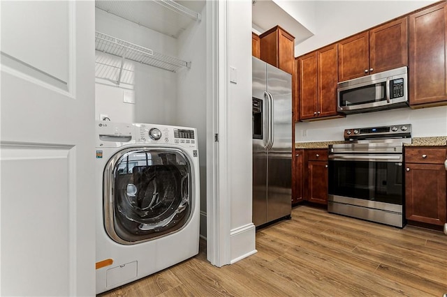 washroom with washer / clothes dryer and light hardwood / wood-style floors