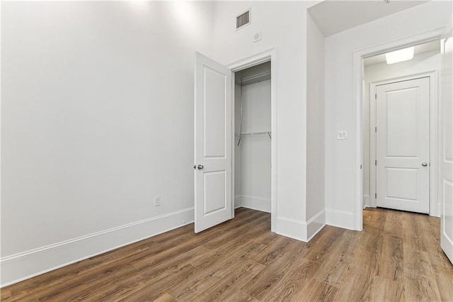 unfurnished bedroom with a closet and hardwood / wood-style flooring