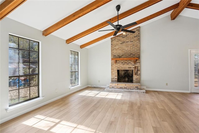 unfurnished living room featuring ceiling fan, high vaulted ceiling, light hardwood / wood-style flooring, beamed ceiling, and a fireplace