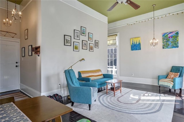 sitting room with ceiling fan with notable chandelier