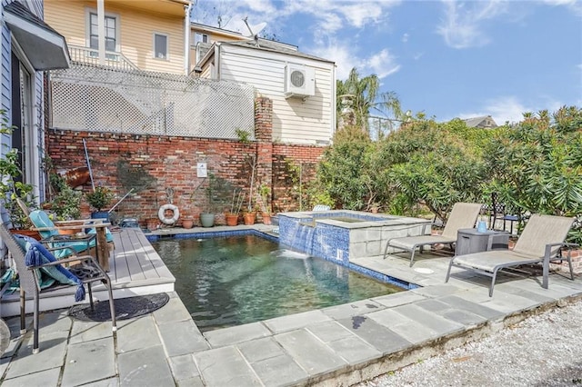 view of swimming pool featuring an in ground hot tub, pool water feature, and a patio