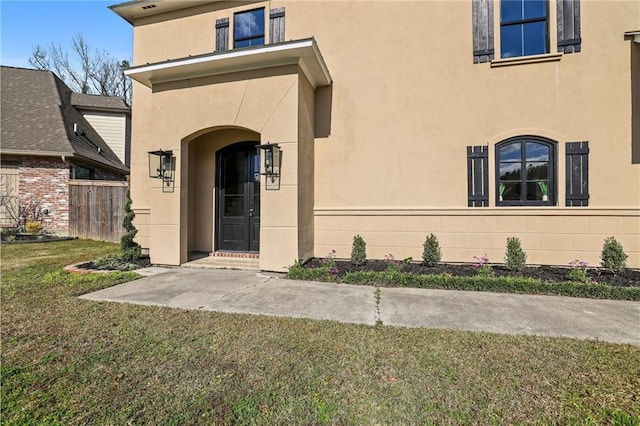 view of exterior entry featuring a lawn