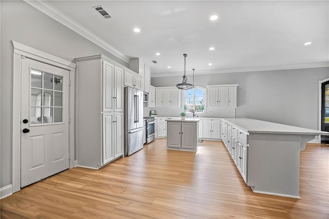 kitchen featuring tasteful backsplash, stainless steel appliances, sink, a center island, and white cabinetry