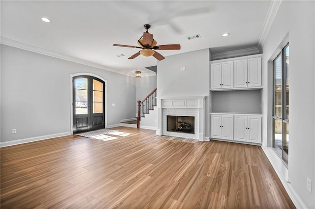 unfurnished living room featuring french doors, a wealth of natural light, and ornamental molding