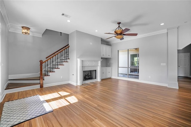 unfurnished living room featuring light wood-type flooring, ceiling fan, and crown molding