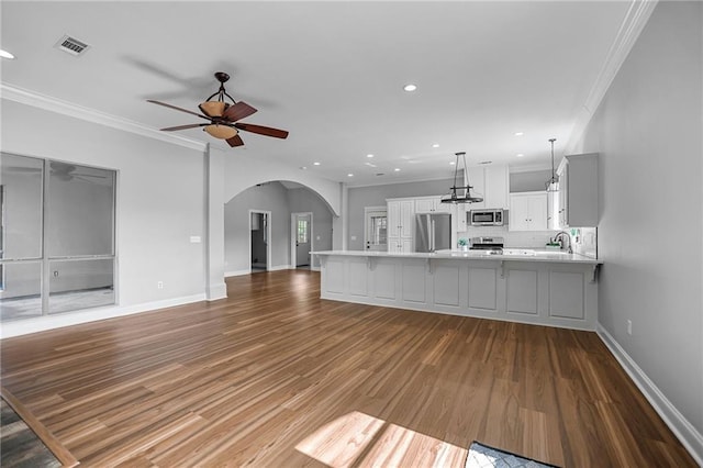 unfurnished living room with light hardwood / wood-style flooring, ceiling fan, crown molding, and sink