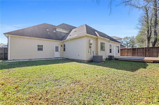 back of property with cooling unit, a deck, and a yard