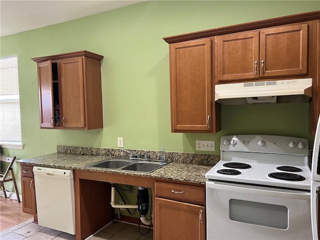 kitchen featuring sink, white appliances, and dark stone counters