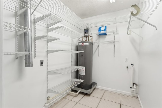 spacious closet with electric water heater and tile patterned flooring