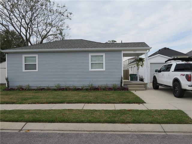 view of front of house with a garage, an outbuilding, and a front lawn