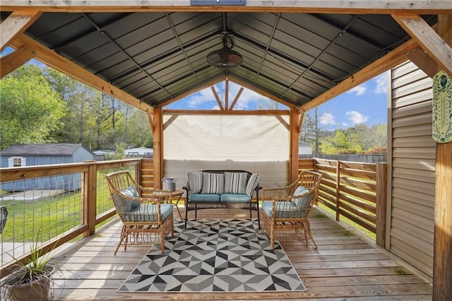 wooden deck featuring a gazebo, a storage shed, and an outdoor hangout area