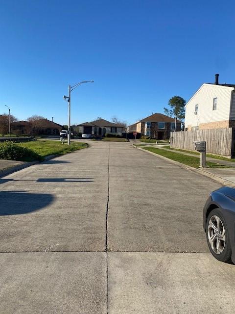 7112 Barrington Ct, New Orleans, LA 70128 - view of concrete street featuring street lights, sidewalks, curbs, and a residential view