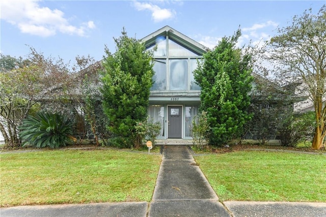 view of property hidden behind natural elements featuring a front lawn