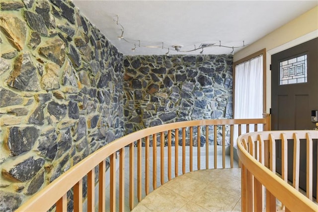 corridor featuring tile patterned flooring and rail lighting