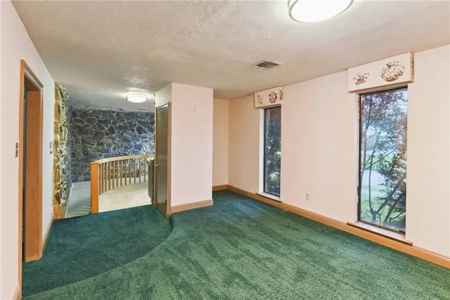 carpeted spare room featuring a textured ceiling