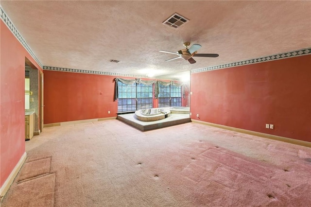 carpeted empty room featuring ceiling fan, crown molding, and a textured ceiling