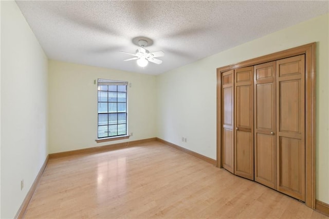 unfurnished bedroom with ceiling fan, light hardwood / wood-style floors, and a textured ceiling