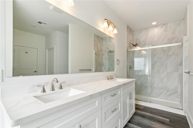 bathroom with wood-type flooring, an enclosed shower, and vanity