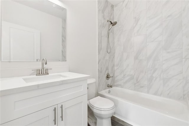 full bathroom with vanity, tiled shower / bath, and toilet