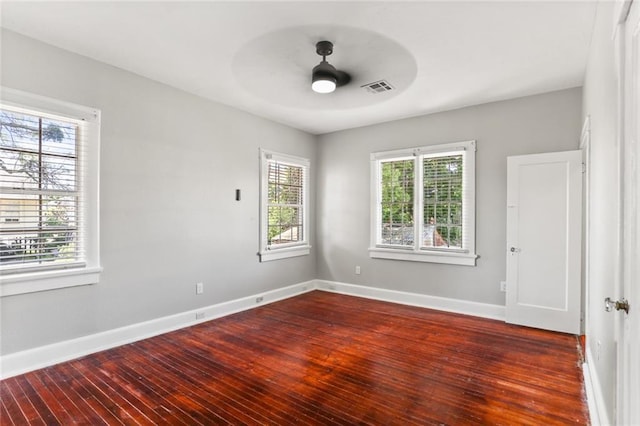 unfurnished room with plenty of natural light, ceiling fan, and dark wood-type flooring