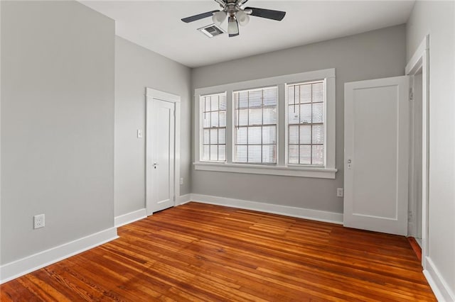 empty room with hardwood / wood-style floors and ceiling fan