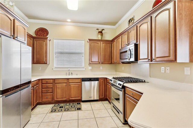 kitchen with appliances with stainless steel finishes, ornamental molding, light tile patterned floors, and sink