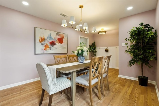 dining room featuring an inviting chandelier and light hardwood / wood-style flooring