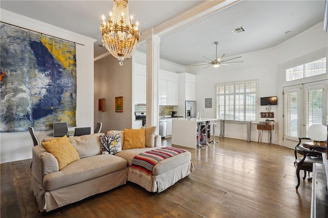 living room featuring ornate columns, ornamental molding, hardwood / wood-style flooring, ceiling fan with notable chandelier, and a high ceiling